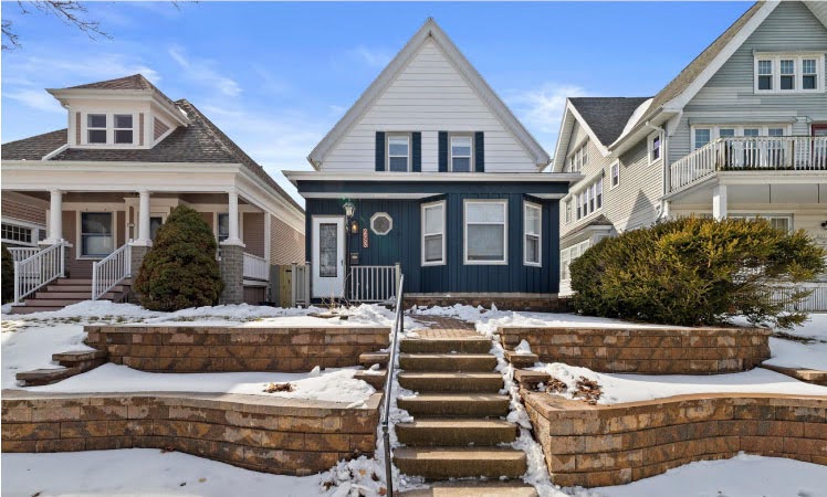 Street-level view of three distinct residential homes in the Bay View neighborhood of Milwaukee on a sunny winter day. 