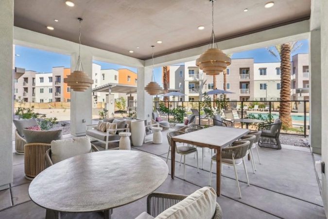 View of outdoor lounge and dining area at a modem apartment community, highlighting amenities that factor into the pros and cons of living in Casa Grande, AZ.