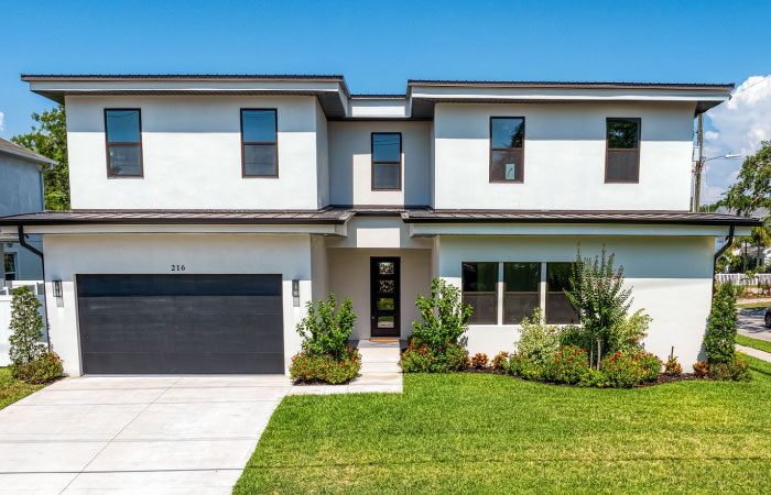 A large, single-family home with a stucco exterior and a flat roof, located in the desirable Swann Estates neighborhood of Tampa, Florida.