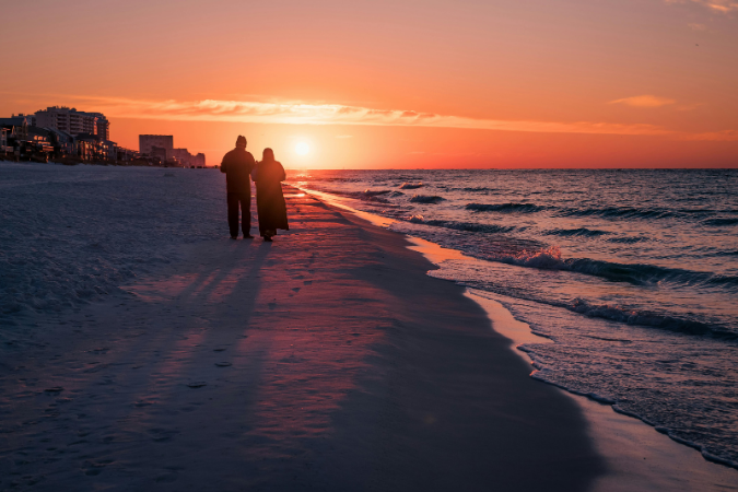 A couple illuminated by the setting sun on a beach in Jacksonville.