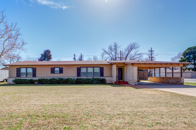 A one-story home in Tech Terrace — one of the best Lubbock neighborhoods — featuring a brick and stone exterior and a carport.