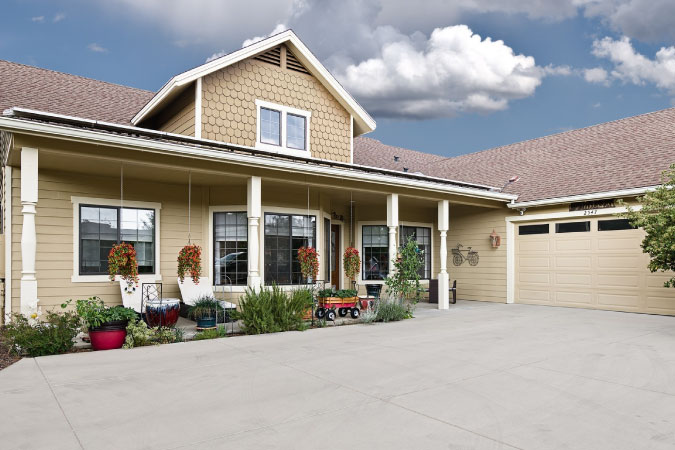 Exterior view of a large, split-level home in Prescott Lakes — one of the best Prescott neighborhoods — featuring a covered porch, two-car garage, and expansive driveway.