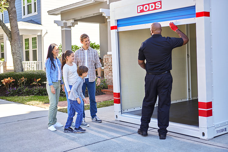 A family of four looks on as a PODS driver shows them the inside of their PODS portable moving container, which they plan to use to move to one of the safest neighborhoods in Houston.