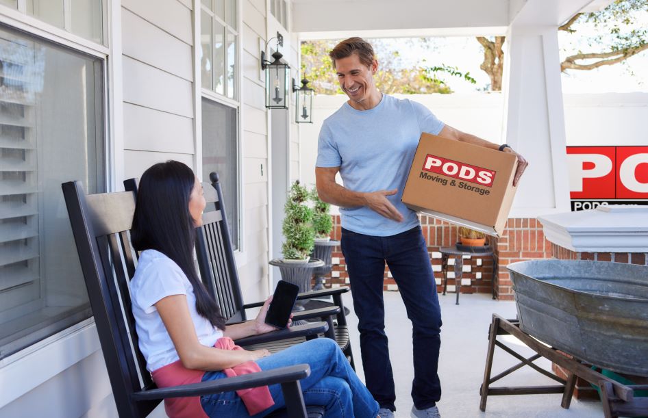 A young couple regroups on their porch as they pack their PODS container.