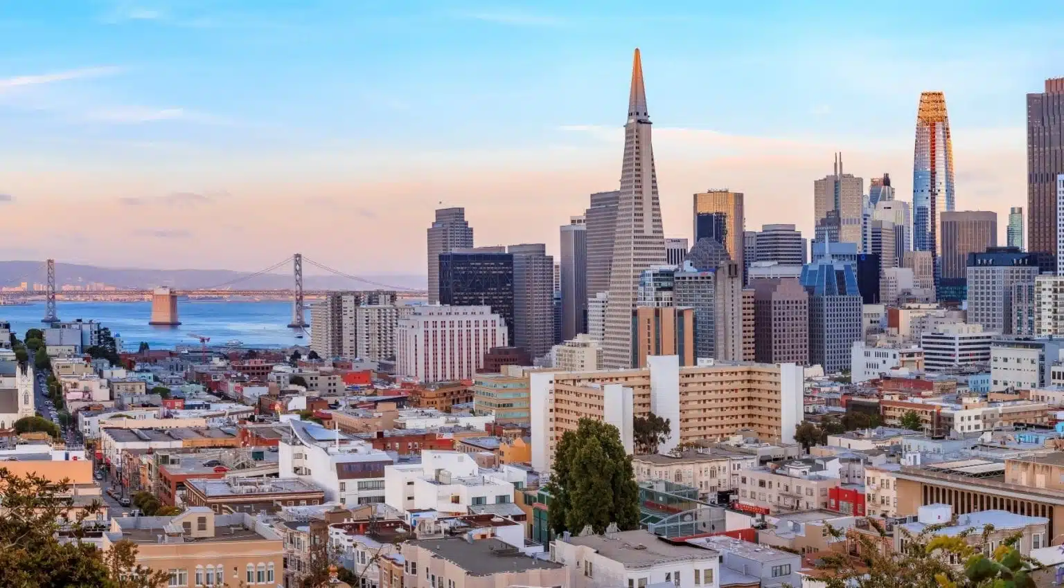 Living in San Francisco gives residents access to gorgeous cityscapes, like this one seen just before sunset with the San Francisco-Oakland Bay Bridge in the distance.
