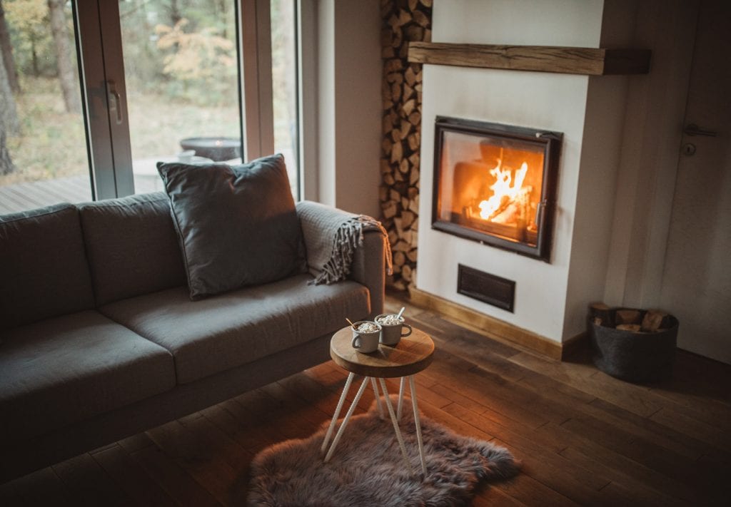 A cozy living room with a blazing fire in the fireplace.
