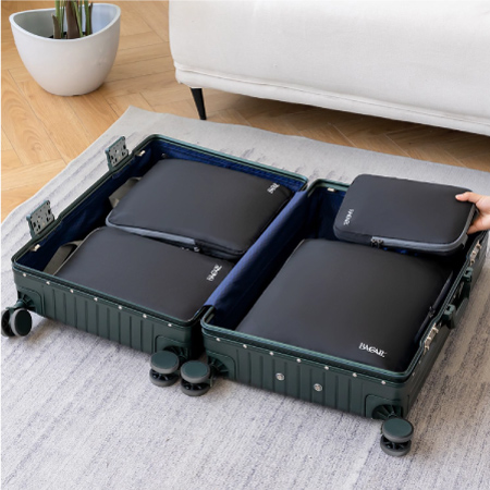  A 4-piece set of compression packing cubes in different sizes being placed in a suitcase