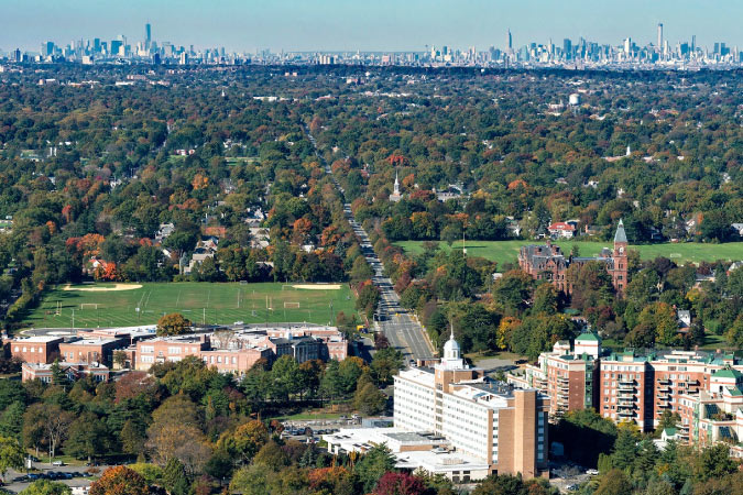  Aerial view of Garden City, New York, on a summer day with the big city in the background.