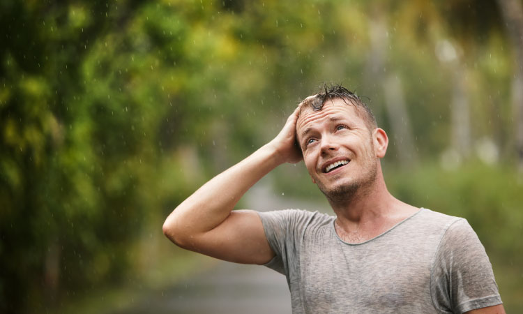 A young man pauses to look up at the sky during a refreshing afternoon rain storm in Columbia, South Carolina.