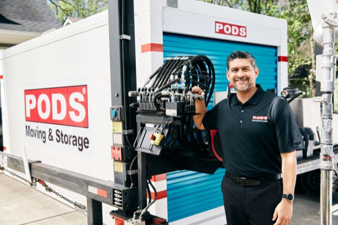 PODS truck driver standing in front of a PODS storage container during a self-service moving, helping through the experience of moving by yourself.