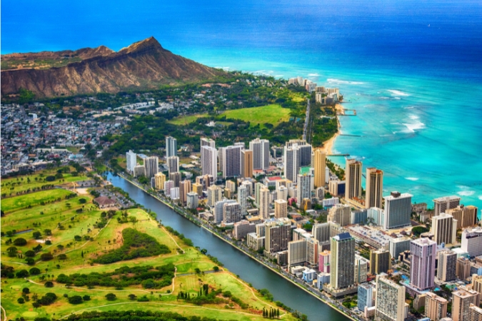 Aerial view of Waikiki’s coastline in Honolulu, Hawaii, one of the top states with the best weather, with the Diamond Head volcanic crater rising in the background.
