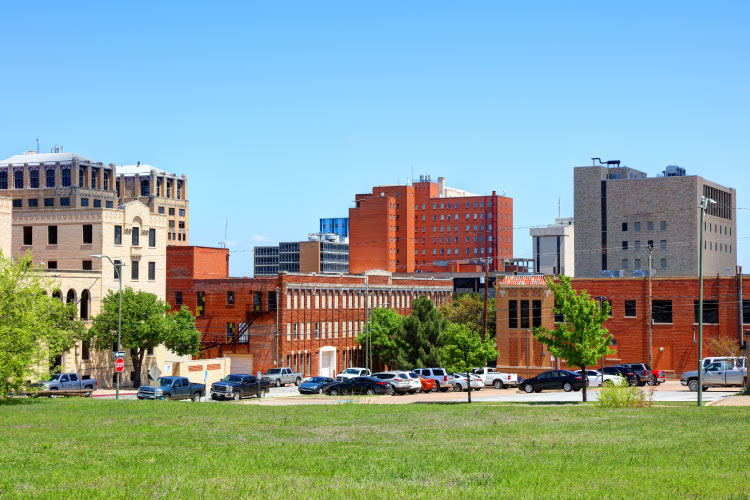 A sunny view of the charming skyline of Wichita Falls, Texas, seen from across an expansive lawn. 