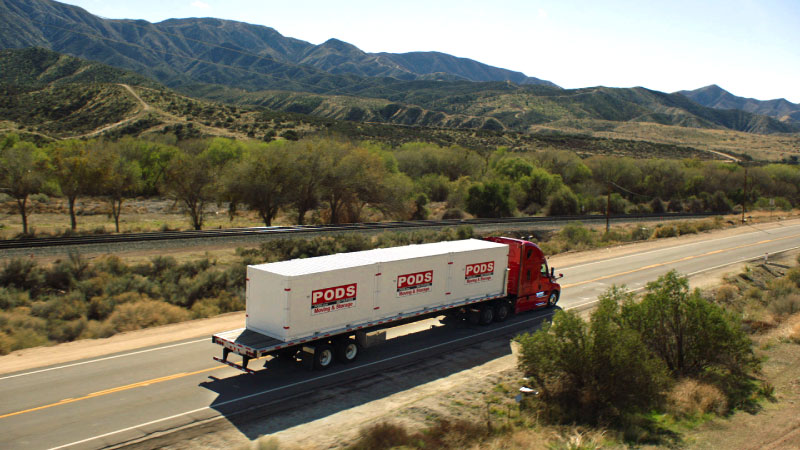 A PODS truck transporting three PODS portable moving containers to Edmonton.