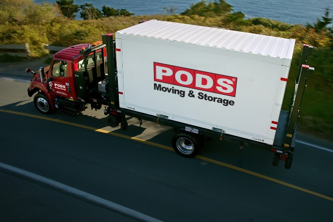A PODS truck transporting a portable moving container along a coastal highway toward one of the most popular cities to move to in 2026.