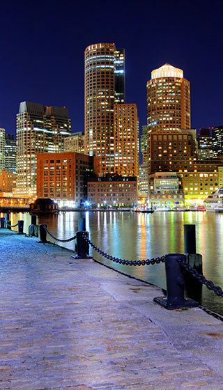 The city of Boston at night as seen from the harbor