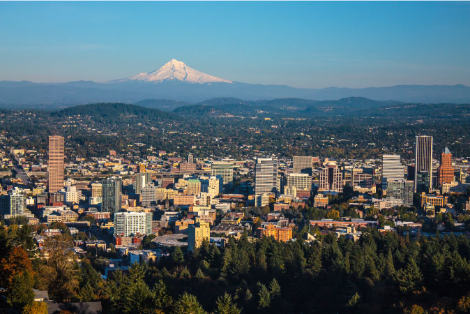 Distant summer view of the city of Portland, Oregon, with snowy Mount Hood in the background. 