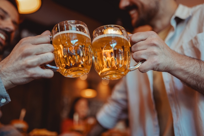 Two people living in Franklin, Tennessee, clink their beer glasses together in a local bar.