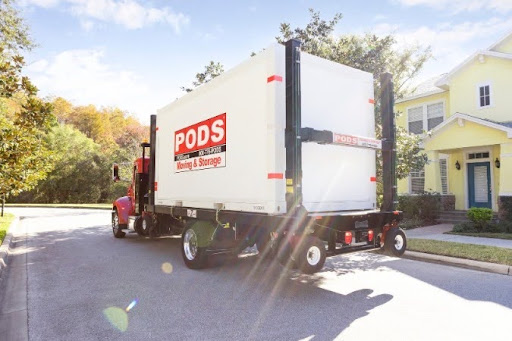 A PODS truck is transporting a portable moving container through a residential neighborhood to the home of a family living in St. George, Utah.