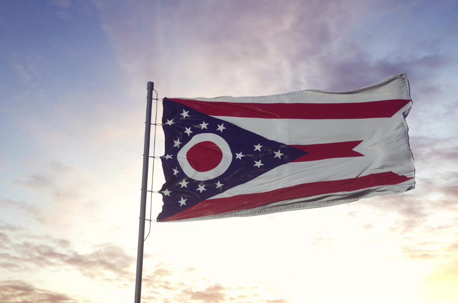 The Ohio state flag blowing in the wind at sunset.