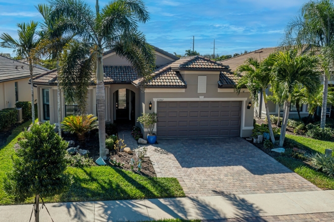 Single-story house with a tiled roof, palm trees, and landscaped yard – a good example of the homes you’ll find when moving to North Port, FL.