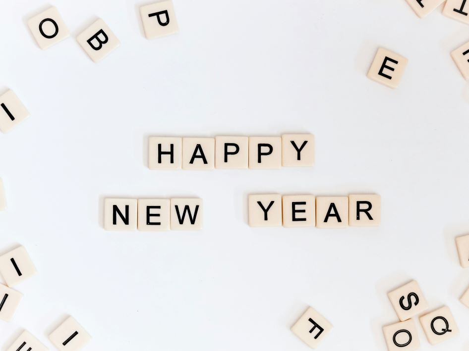 Scrabble pieces that spell out Happy New Year, with a few other letters scattered about.