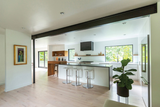 A bright kitchen showcasing minimalist home remodeling ideas, including white walls, light wood floors, and open shelving