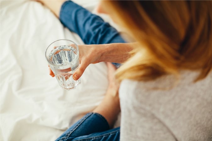 A woman drinking water while taking a break from packing