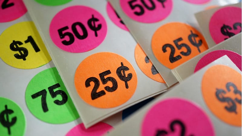 Several sheets of colorful pricing stickers for pricing garage sale items in accordance with a yard sale pricing guide for 2024