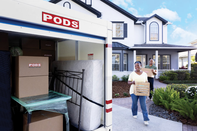 A couple is carrying items to a PODS portable storage container, which is nearly full of moving boxes and furniture.