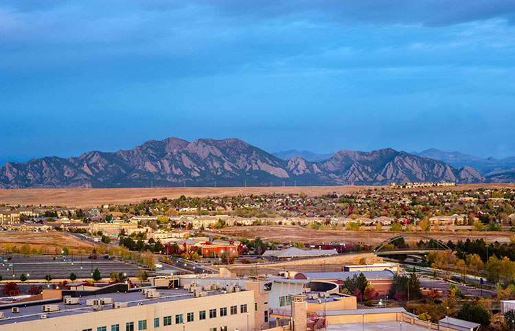 A wide-angle panorama of Broomfield, Colorado with the Flatiron Mountains in the background.