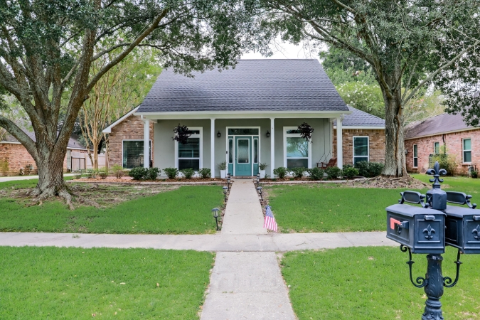 One-story Acadian-style home in South Louisiana with a manicured lawn and mature oak trees, capturing the character of Airline/Jefferson — one the best Baton Rouge neighborhoods.
