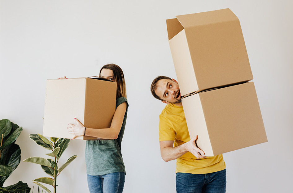 A couple carrying full boxes packed for their move
