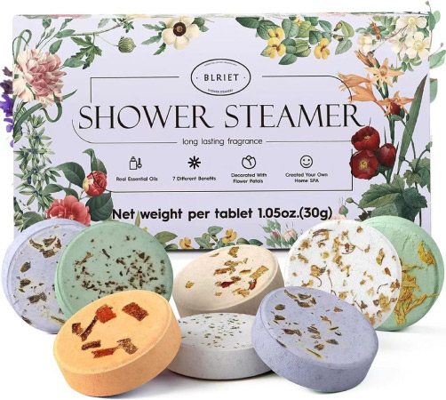 A display of eight multi-colored, herbal shower steamers with the purple floral packaging displayed in the background.