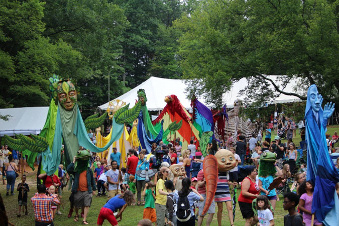 Durham locals take part in a parade of tall, colorful puppets during the annual Festival for the Eno River.