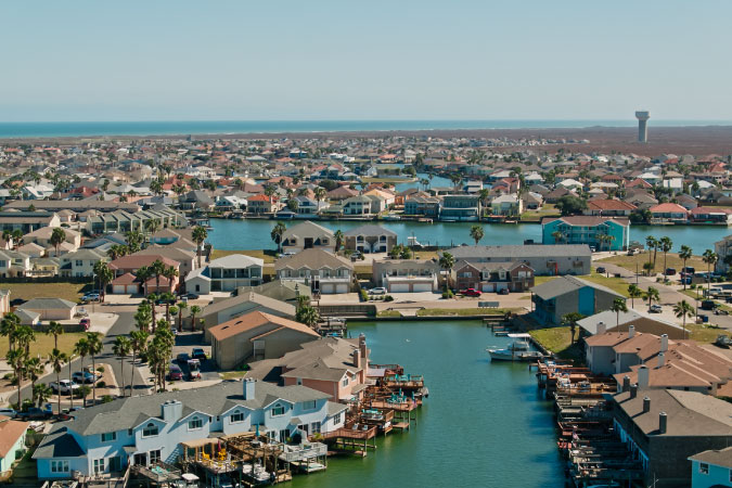 Waterfront neighborhoods on Padre Island in Corpus Christi, Texas, featuring private docks and multi-family homes.