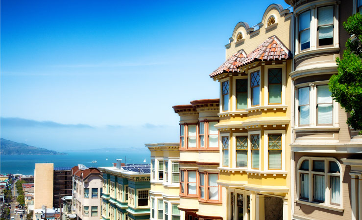 Rows of homes in San Francisco, California, with a clear view of the blue sky in the background.