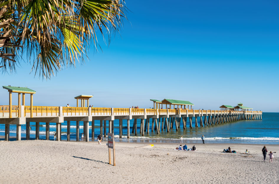 A view of the pier on Folly Beach in South Carolina on a sunny summer day.