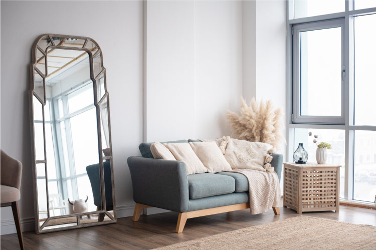 This small living room features a window wall, which lets large amounts of natural light into the room, and a large mirror, which makes the space seem larger. 