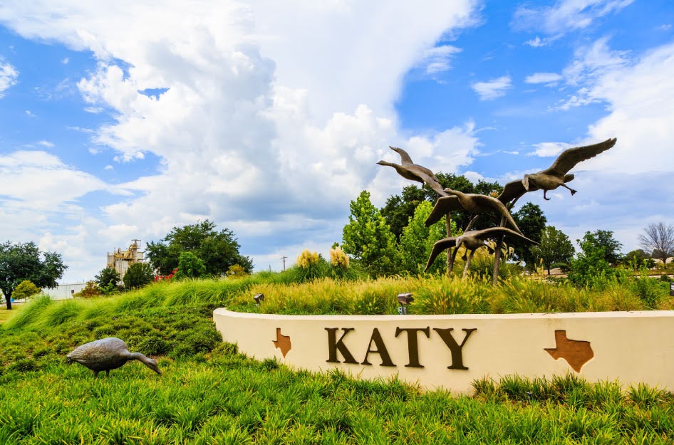 A short wall on a grassy hill in Katy, Texas, is adorned with the word “KATY” and several bronze sculptures of geese.