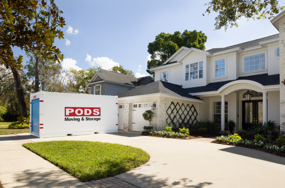 A PODS container sits in the driveway of a family who just moved with containers to their new home.
