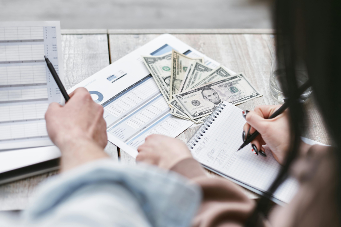 A close up of someone planning a monthly budget so they can cut costs when moving.