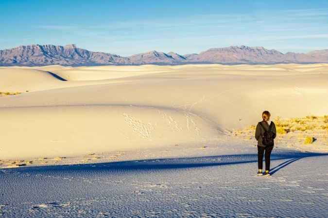 A woman is admiring the stunning panoramic views in White Sands National Park in New Mexico, a state ranked among the best states to teach in for teacher salary growth and pension benefits.