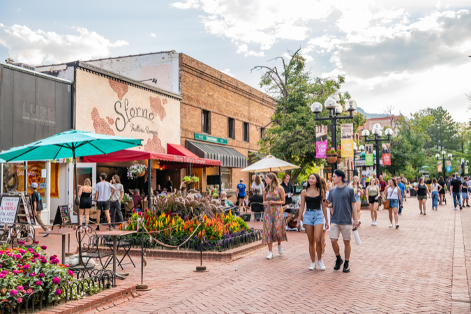 Locals living in Boulder, CO, explore the colorful shops of Pearl Street on a bright weekend afternoon.