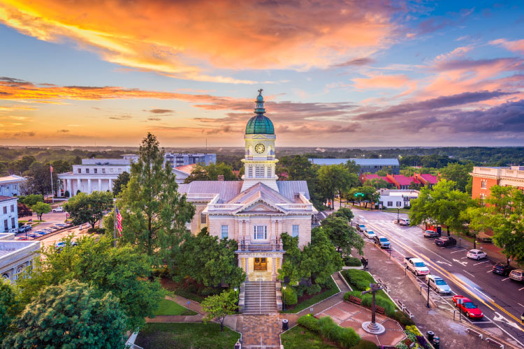Aerial view of Downtown Athens, Georgia, as the sun is setting behind a prominent city building.
