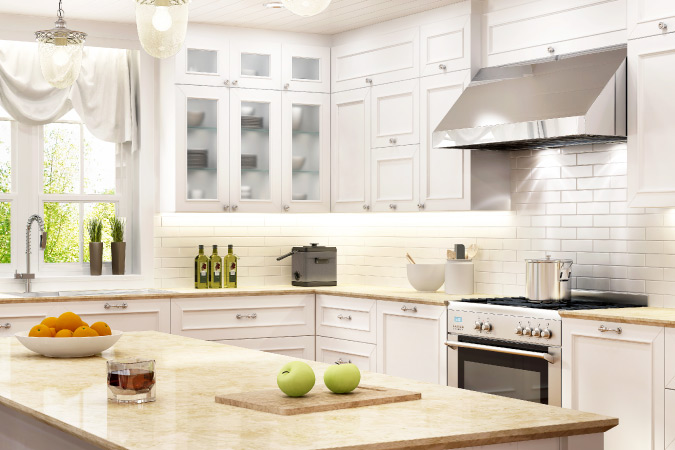 timeless kitchen design, featuring white shaker-style cabinets, stainless steel appliances, and stone countertops — a good example of some classic kitchen remodeling ideas.