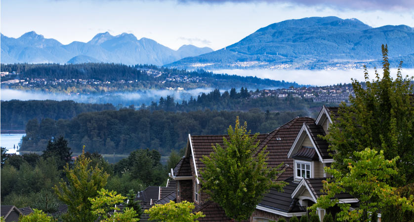 Residential area at Surrey near Fraser river in autumn in early morning, Coquitlam cityscape in the background.