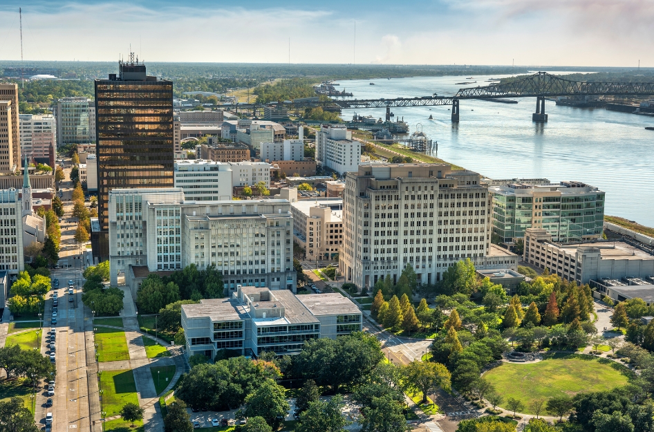Skyline view of Downtown — one of the best Baton Rouge neighborhoods — with tall city buildings, the Mississippi River, and lush city parks.