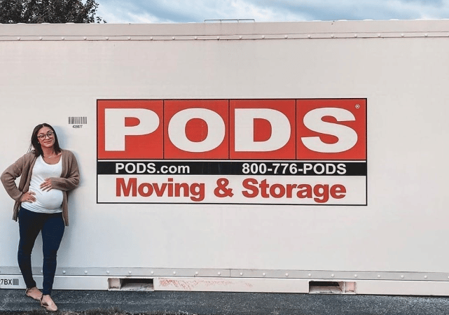 Jehlisah Rae rests her arm on her baby bump while smiling and leaning against her PODS portable moving container.