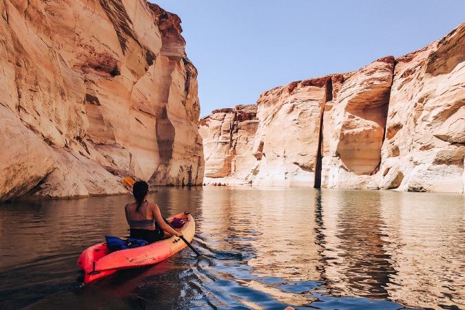Woman kayaking through canyon waters in the Lake Powell recreation area near Page, Arizona, one of the warmest states in the U.S.