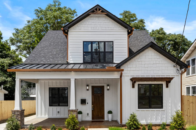 A white, two-story home in the Kenwick neighborhood of Lexington, Kentucky, featuring a covered porch and two front-facing gables.